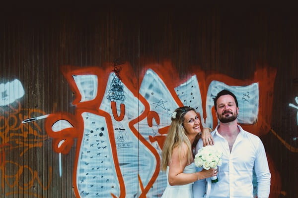 Couple standing in front of graffiti wall in Italy