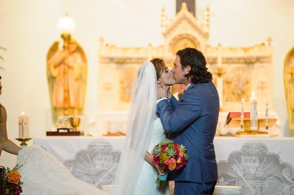 Bride and groom kiss at altar