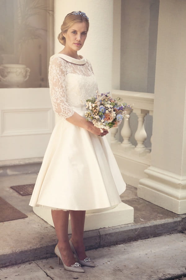 Bride in tea length dress holding bouquet