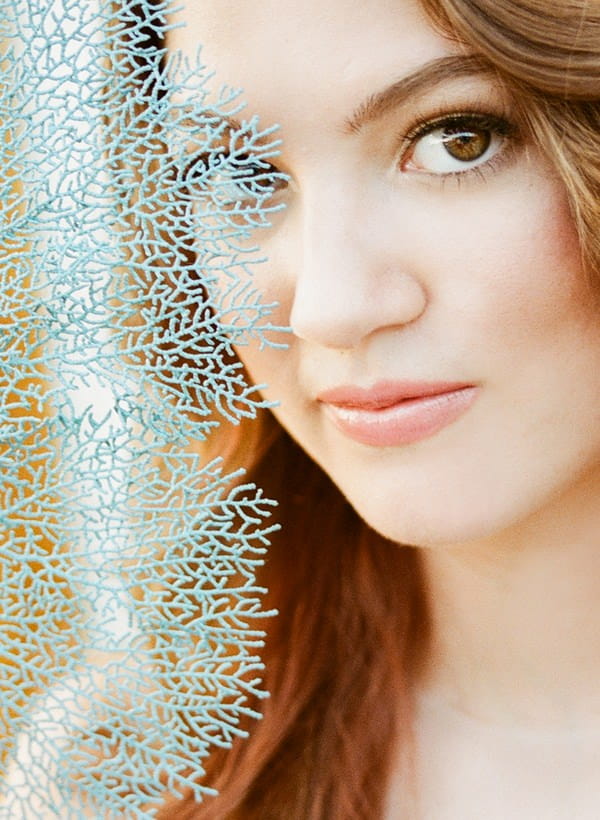 Blue fan over bride's face