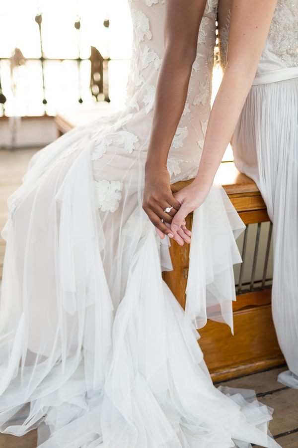 Two brides holding hands