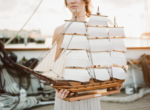 Bride holding up model of the Tall Ship Elissa