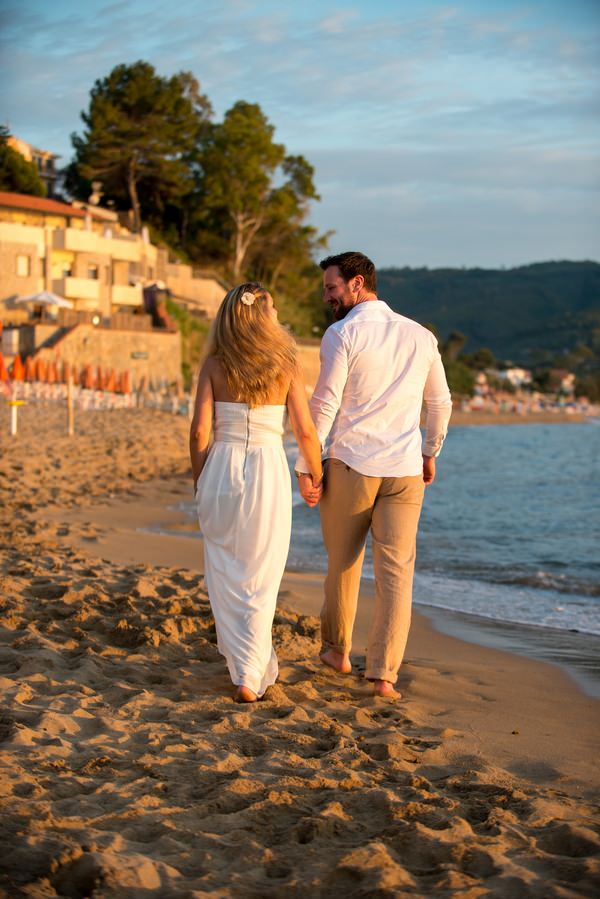 Couple walking on beach in Italy