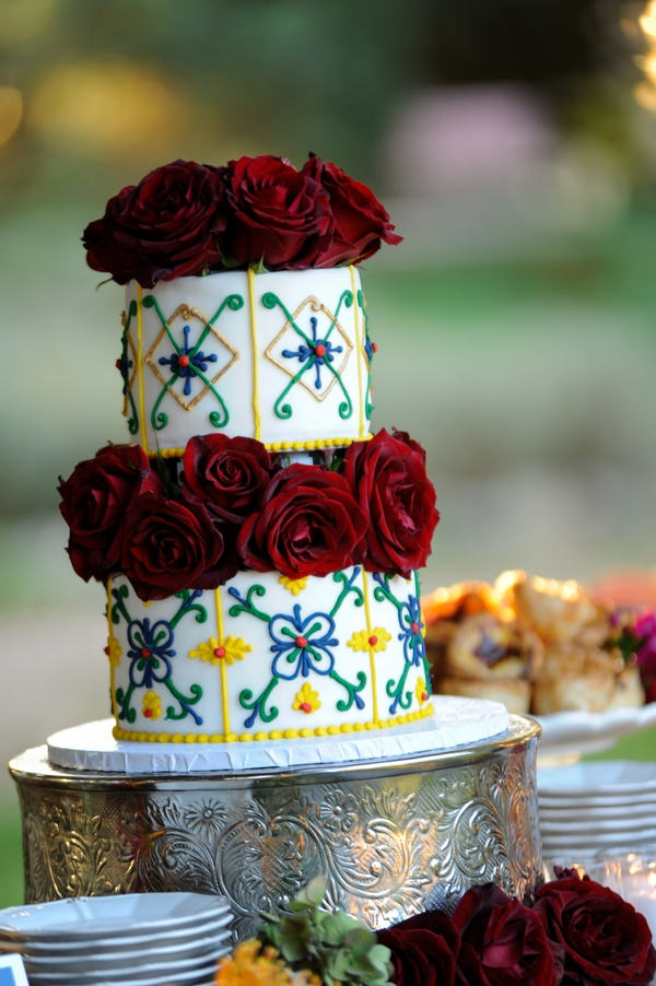 Wedding cake with yellow and blue detail and red flowers