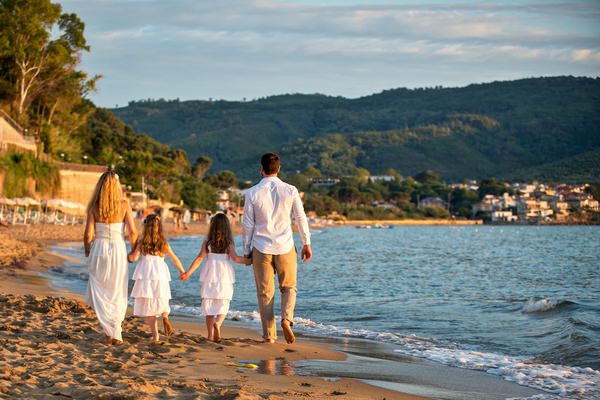 Family walking on beach in Italy