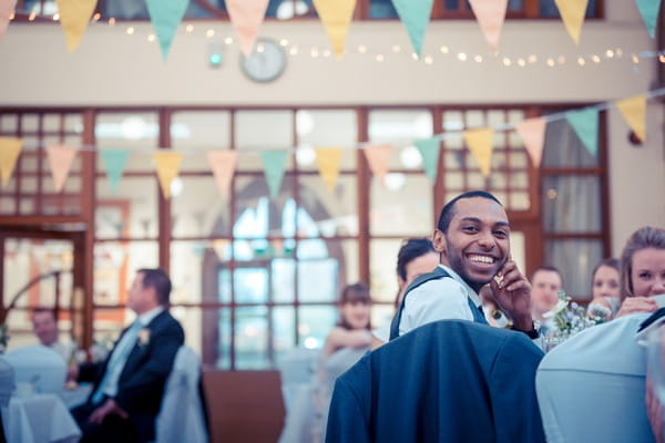 Wedding guest smiling as he listens to speech