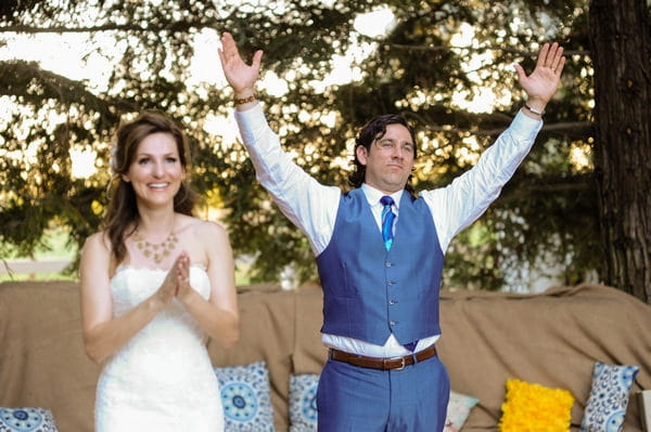 Bride and groom clapping with hands in air