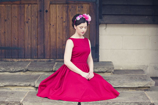 Bride in red vintage wedding dress sitting on floor