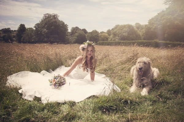 Bride laying on grass next to dog