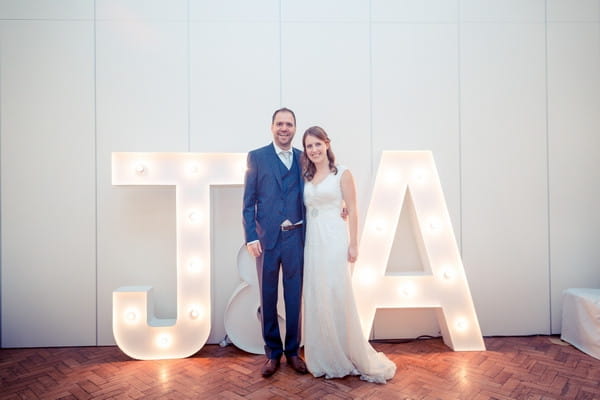 Bride and groom in front of large illuminated letters