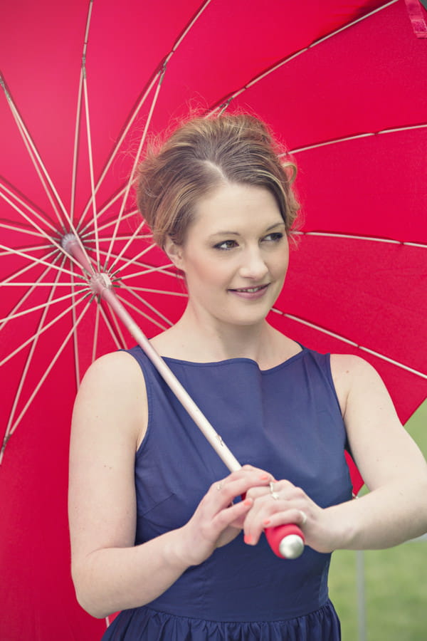 Bride holding red umbrella