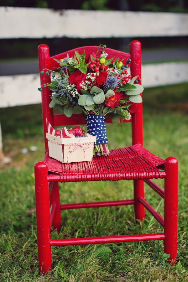 Bouquet and punnet of strawberries on red chair