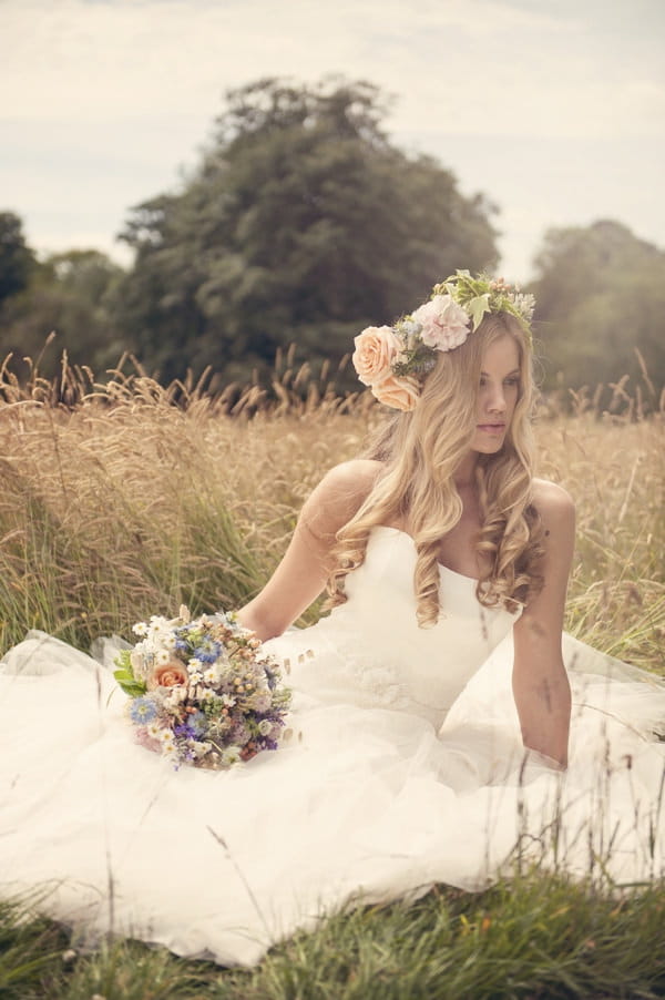 Boho bride sitting on grass