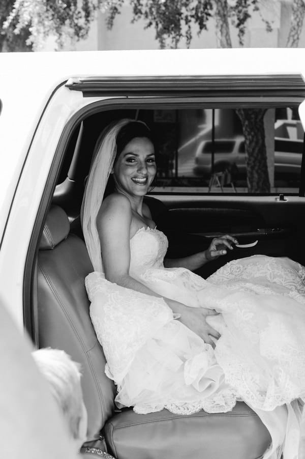Bride in back of wedding car