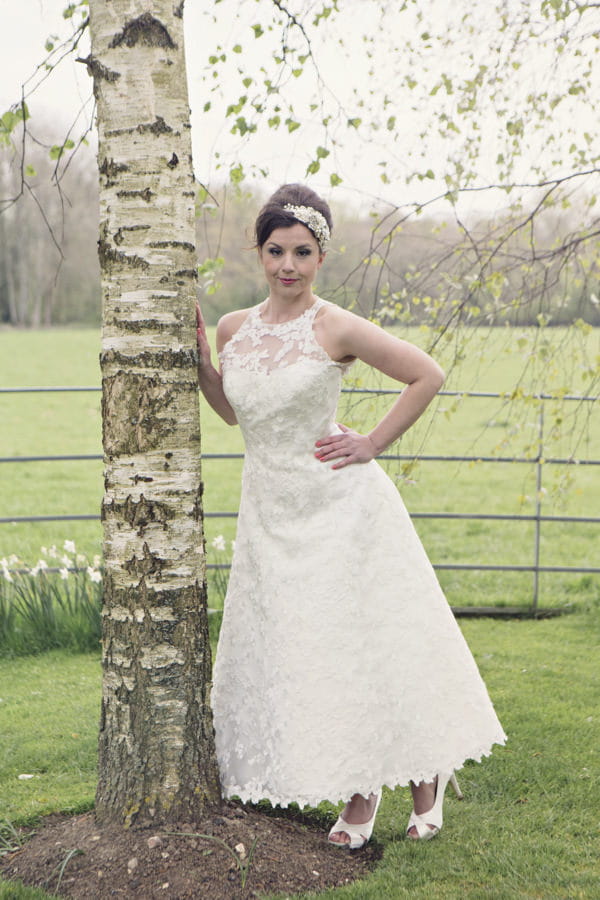 Bride standing next to tree