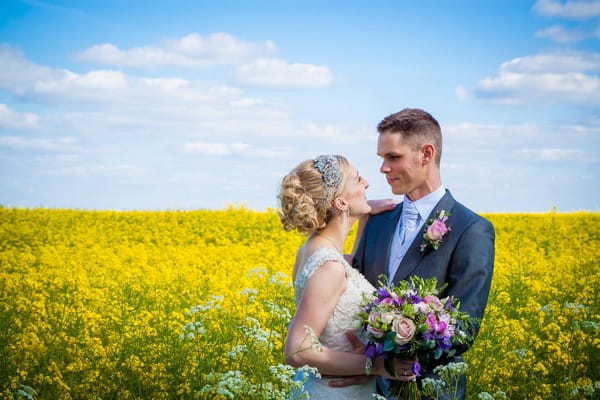 Bride and groom in yellow field - Picture by Amanda Karen Photography