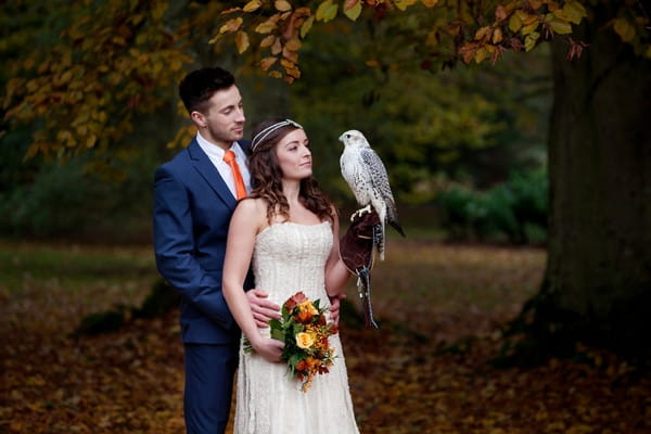 Bride and groom holding hawk