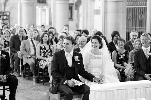 Bride and groom sitting at front of church
