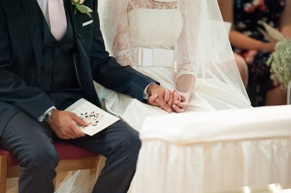 Bride and groom holding hands in church