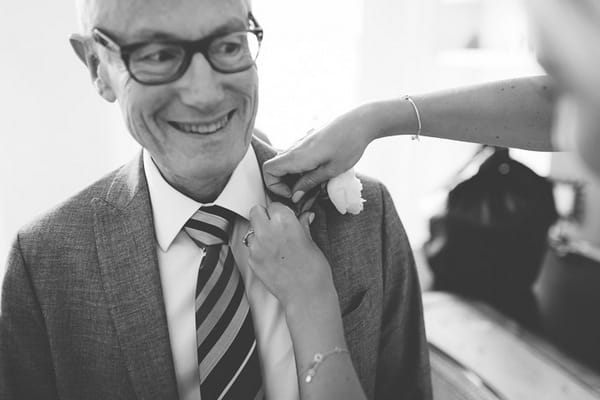 Bride's father having buttonhole put on