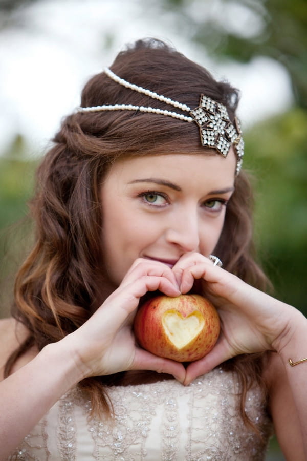 Bride holding apple with heart shape cut out