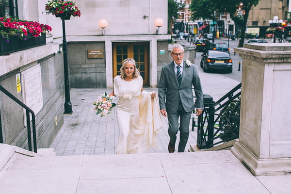 Bride and father walking up steps to Islington Town Hall