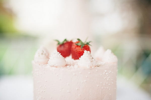 Strawberries on top of small pink wedding cake