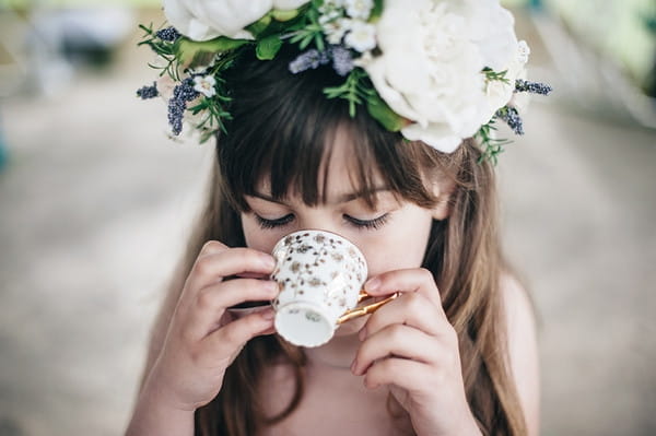 Young flower girl drinking tea