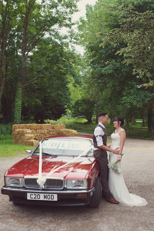 Bride and groom by wedding car