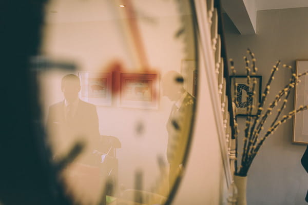 Reflection of groom in clock