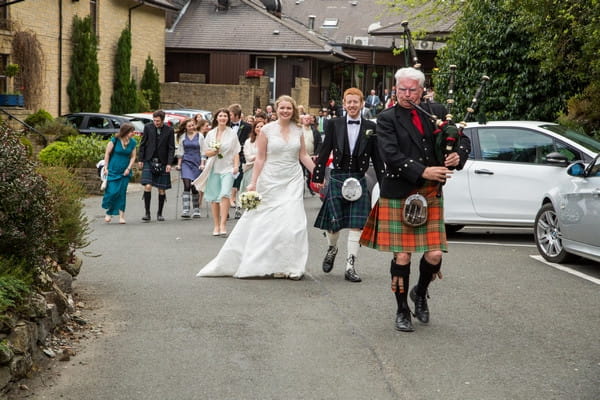 Bagpiper leading wedding party to venue