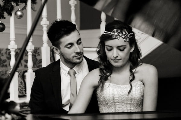 Bride and groom sitting at piano