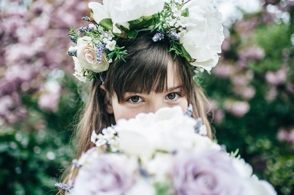 Flower girl hiding face with bouquet