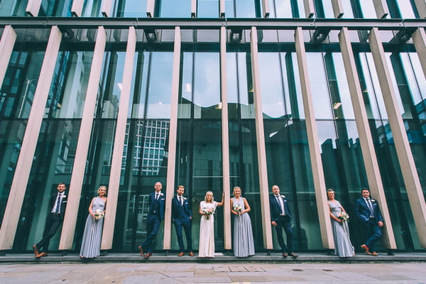 Bridal party in front of glass fronted building in London