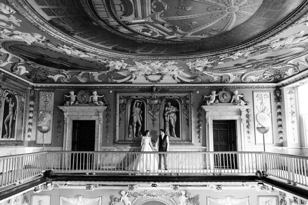 Bride and groom on balcony inside Moor Park Mansion