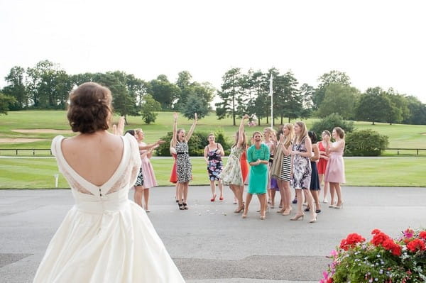 Wedding guests trying to catch bouquet