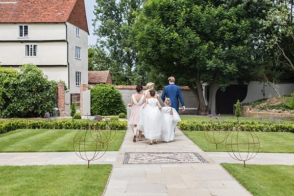Bridal party walking through gardens at Houchins