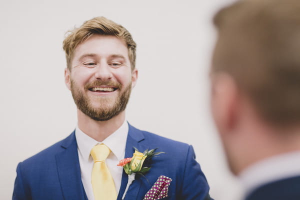 Groom in blue suit smiling