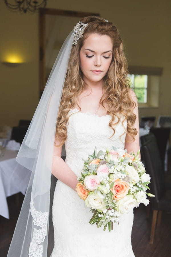 Bride with long veil holding bouquet