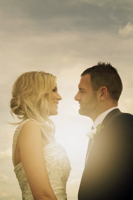 Bride and groom facing each other with sun shining between them - Picture by KTM Photography