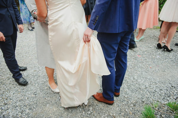 Groom holding up back of bride's dress