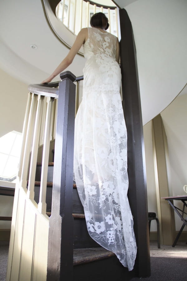 Bride in lace dress going up stairs