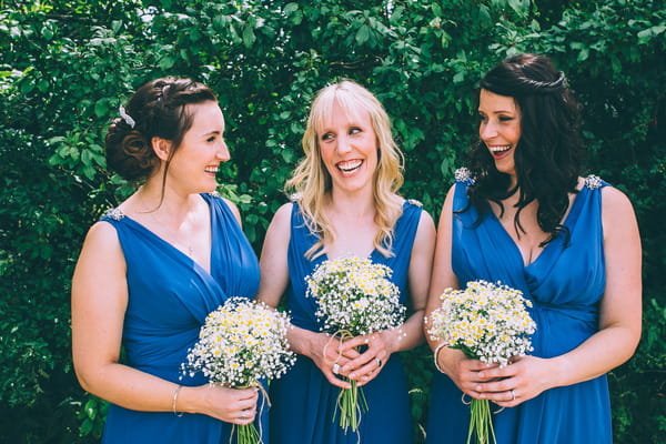 Bridesmaids in blue dresses with chamomile bouquets