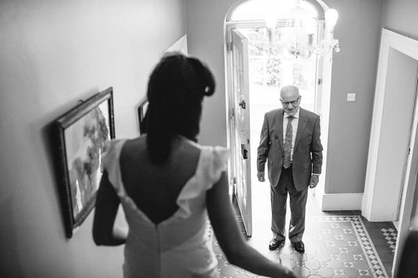 Father watching bride walk down stairs