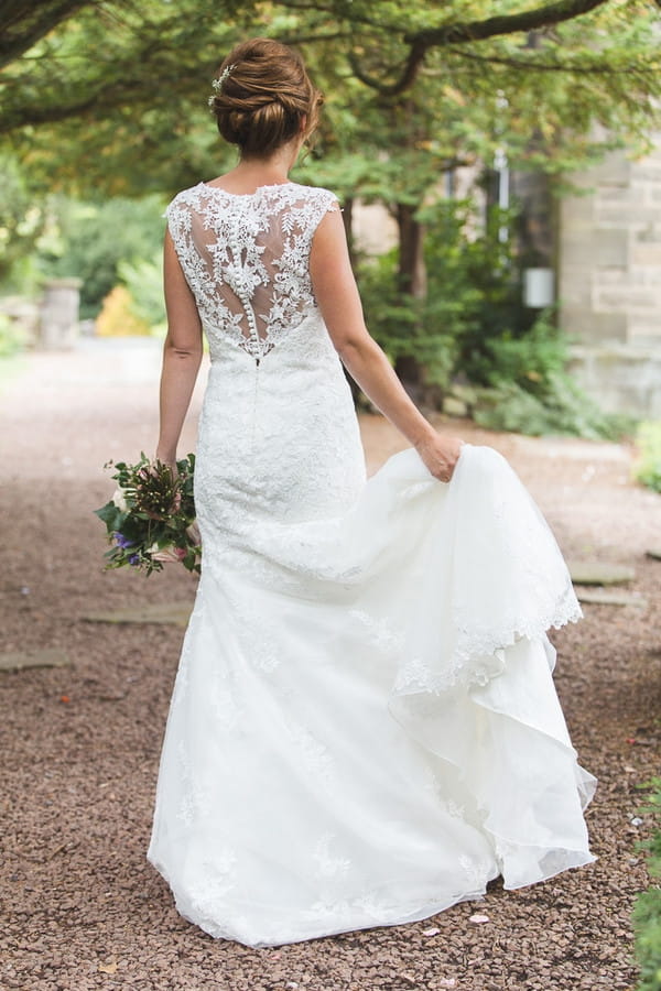 Bride holding up wedding dress