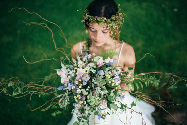 Bride with flower crown holding bouquet at Cosawes Barton