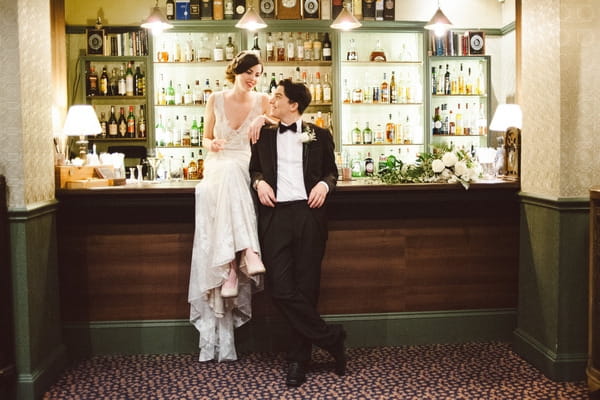 Retro bride sitting on bar with groom