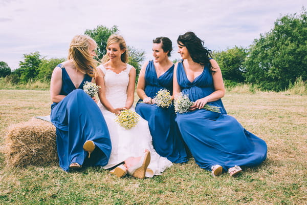 Bride sitting with bridesmaids in blue dresses