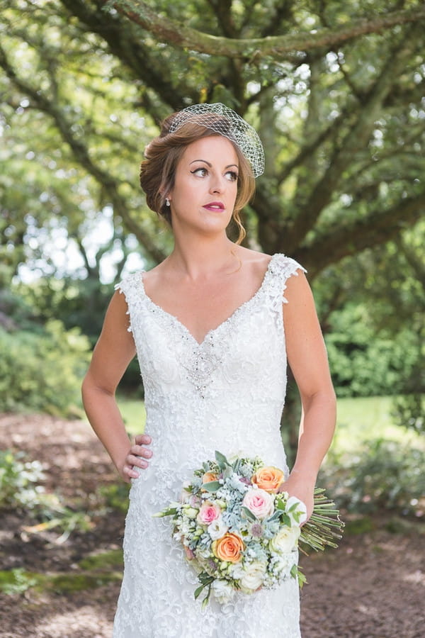 Bride with hand on hip holding bouquet