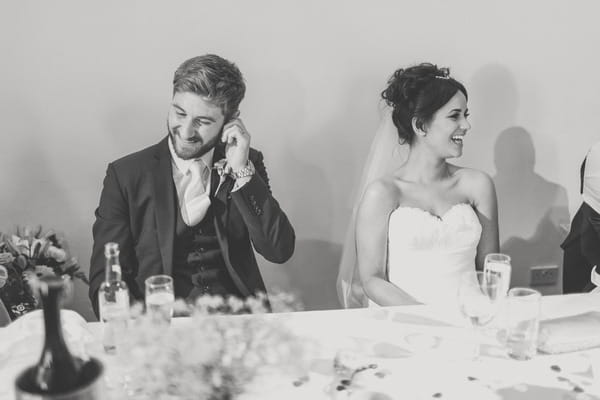 Bride and groom listening to best man speech